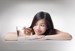 woman looking at a glass of water